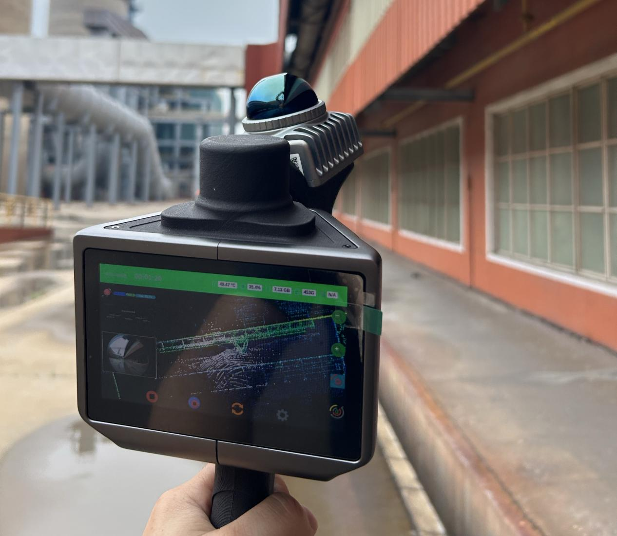 Handheld LiDAR scanner showing live point-cloud capture at the Yingkou plant