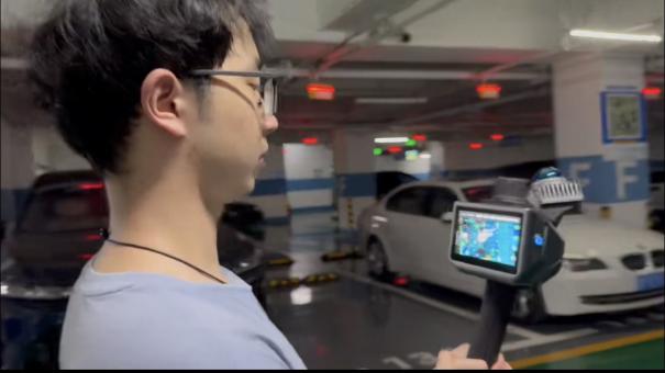 Handheld LiDAR scanner displaying live garage point-cloud capture